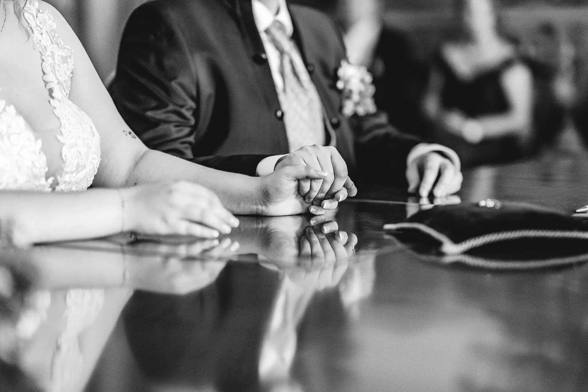 Schwarzweiß: Hände an einem gedeckten Tisch